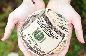 Woman holding wads of money.