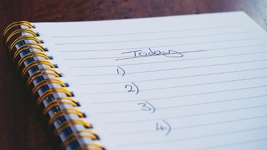 A to-do list on a notepad with today's list of tasks being written out.